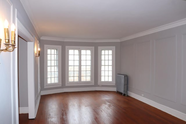 spare room featuring ornamental molding, dark hardwood / wood-style floors, and radiator