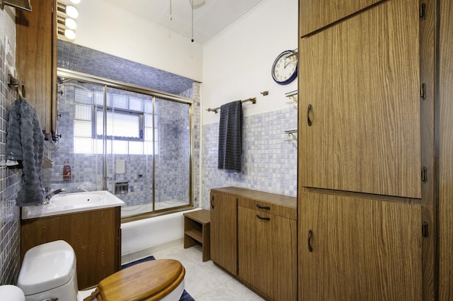 full bathroom featuring enclosed tub / shower combo, tile walls, tile patterned flooring, vanity, and toilet