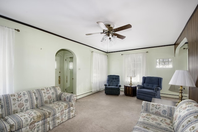 carpeted living room featuring baseboard heating, ceiling fan, and crown molding