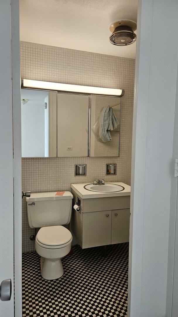 4800 S Chicago Beach Dr Unit 1404S, Chicago, IL 60615 - bathroom featuring tile walls, toilet, and vanity