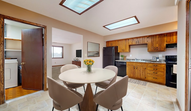 kitchen with washer / dryer, sink, exhaust hood, and black appliances