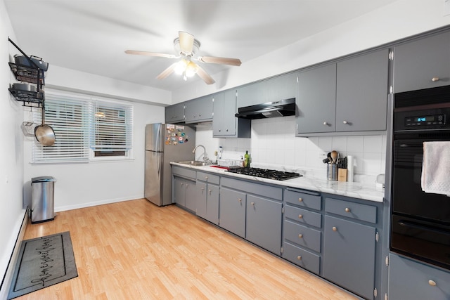 kitchen with stainless steel refrigerator, sink, decorative backsplash, gas stovetop, and light hardwood / wood-style flooring