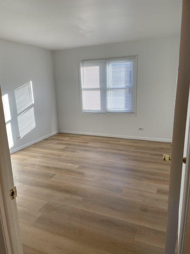 empty room with light hardwood / wood-style flooring