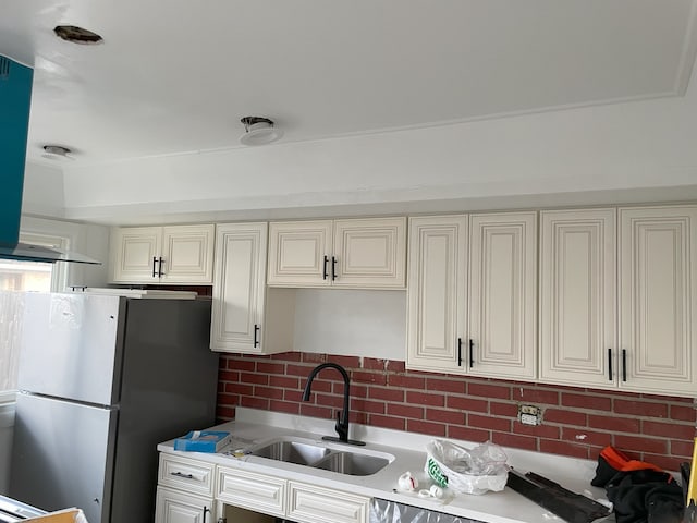 kitchen with sink, backsplash, and stainless steel refrigerator