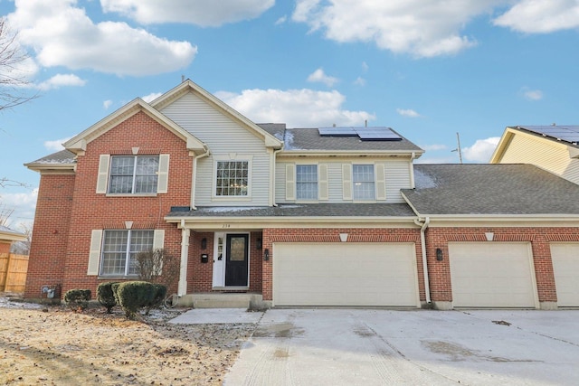 view of property featuring a garage and solar panels