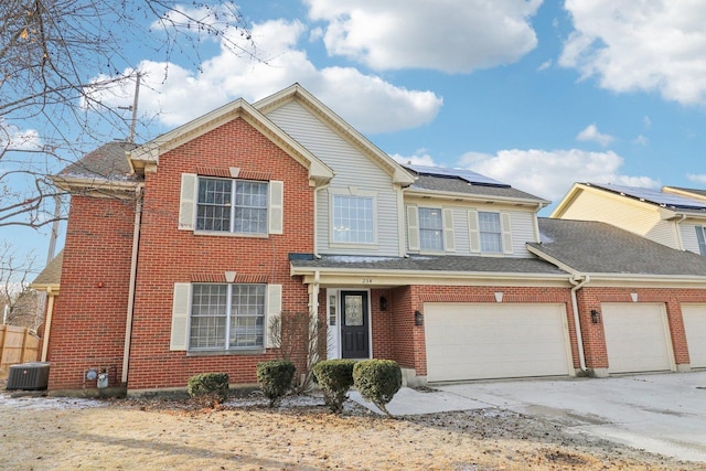 view of front of house with a garage, central AC, and solar panels