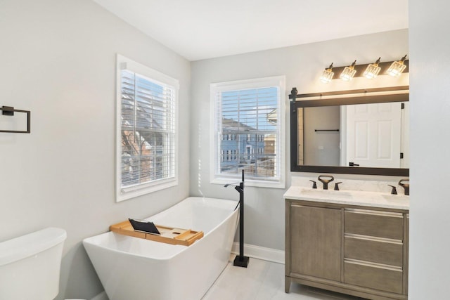 bathroom with a tub to relax in, toilet, and vanity