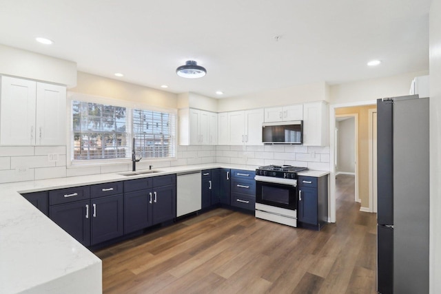 kitchen with white cabinetry, appliances with stainless steel finishes, dark wood-type flooring, and decorative backsplash