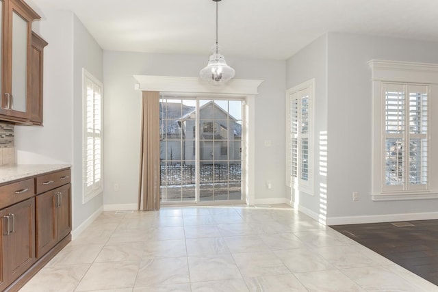 unfurnished dining area with baseboards