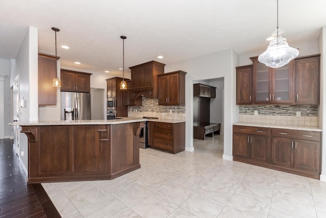 kitchen featuring a peninsula, hanging light fixtures, stainless steel fridge, and glass insert cabinets