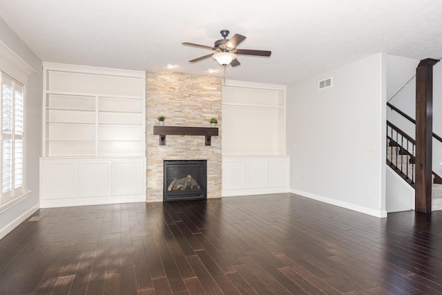 unfurnished living room with dark wood-type flooring, a wealth of natural light, and stairs