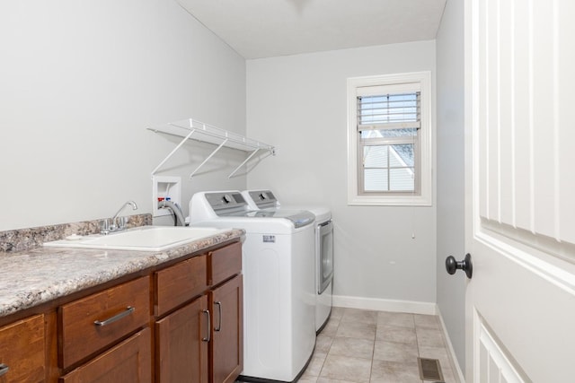 washroom featuring light tile patterned floors, baseboards, visible vents, separate washer and dryer, and a sink