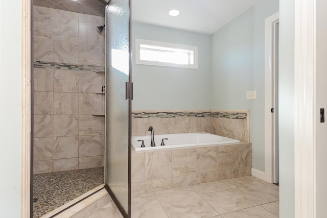 bathroom with a stall shower and a garden tub