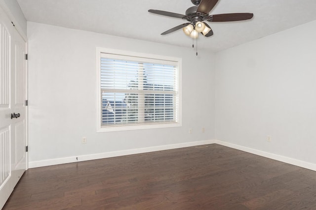 unfurnished room with ceiling fan, baseboards, and dark wood-type flooring