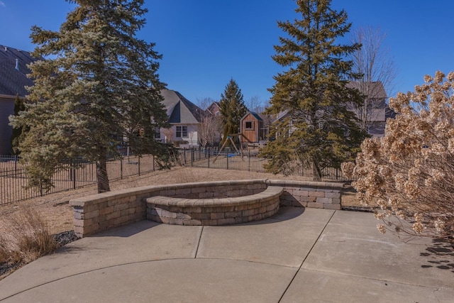 view of patio featuring a playground and fence