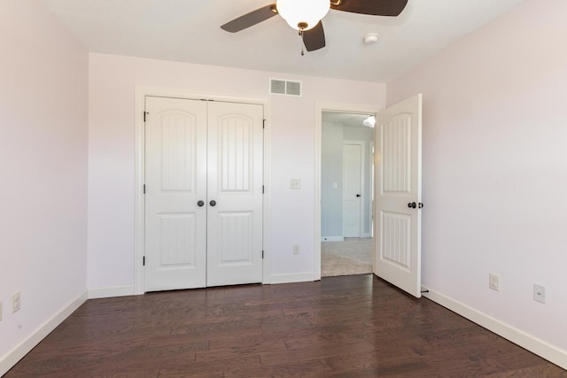 unfurnished bedroom featuring a closet, visible vents, dark wood finished floors, and baseboards