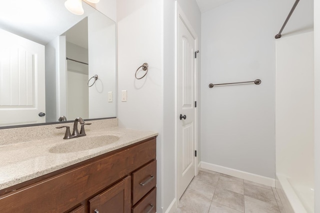 bathroom featuring walk in shower, tile patterned flooring, vanity, and baseboards