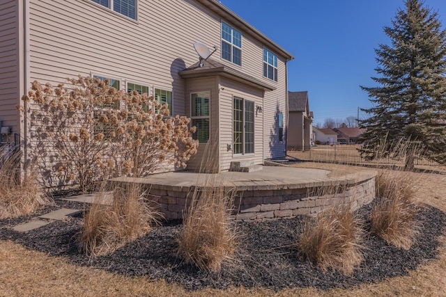 rear view of property featuring a patio and fence