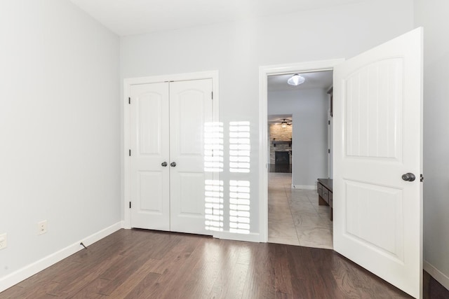 unfurnished bedroom featuring a closet, wood finished floors, and baseboards