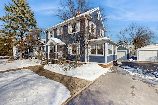 view of front of home featuring a garage, a chimney, and an outdoor structure