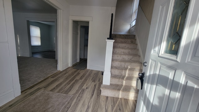 stairway with baseboards, carpet floors, and wood finished floors