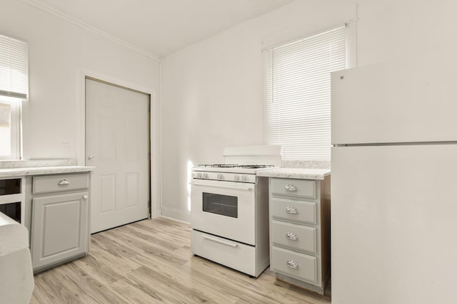 kitchen featuring white appliances, ornamental molding, gray cabinets, and light wood-type flooring