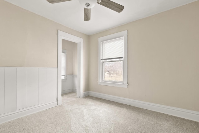 unfurnished room featuring light colored carpet and ceiling fan