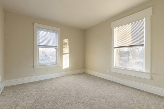 spare room featuring a healthy amount of sunlight and carpet floors