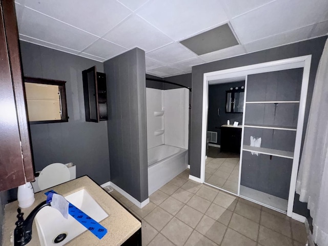 bathroom with vanity, a paneled ceiling, tile patterned floors, and shower / bathtub combination