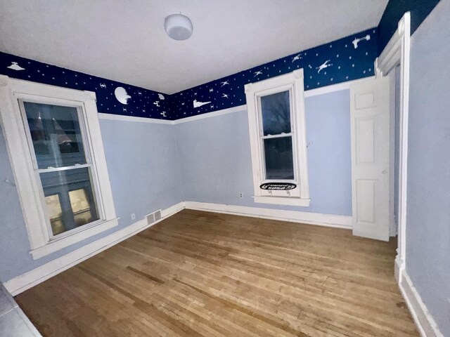 911 S Peoria Ave, Dixon, IL 61021 - empty room with baseboards, visible vents, and wood finished floors
