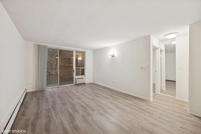 empty room with a baseboard heating unit and light hardwood / wood-style flooring