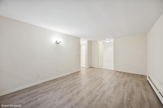 empty room featuring light hardwood / wood-style floors and a baseboard heating unit