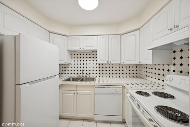 kitchen featuring sink, tasteful backsplash, light tile patterned floors, white appliances, and white cabinets