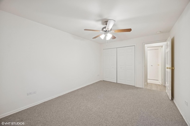 unfurnished bedroom with ceiling fan, light colored carpet, and a closet