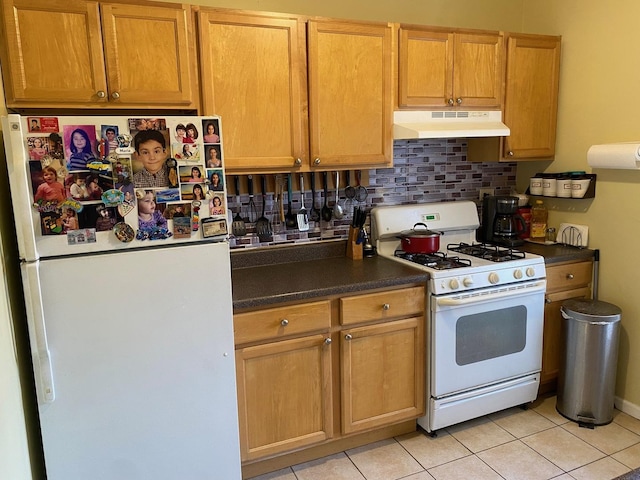 kitchen with tasteful backsplash, light tile patterned flooring, and white appliances