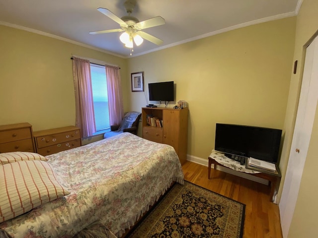 bedroom with crown molding, hardwood / wood-style floors, and ceiling fan