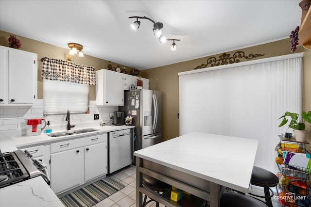 kitchen featuring white cabinetry, stainless steel appliances, sink, and backsplash