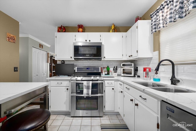 kitchen featuring white cabinetry, appliances with stainless steel finishes, sink, and backsplash