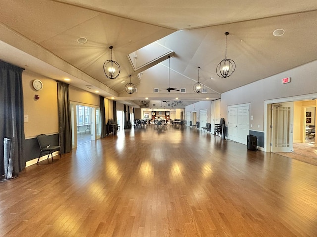 interior space featuring high vaulted ceiling, hardwood / wood-style floors, and an inviting chandelier