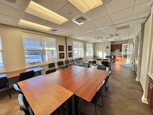 dining space with a drop ceiling