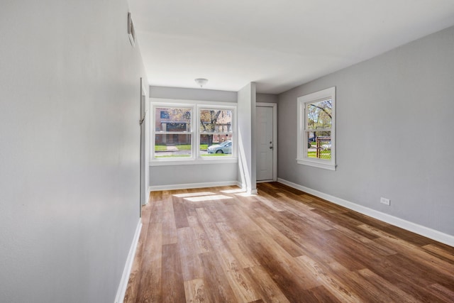 empty room with light wood finished floors and baseboards