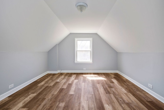 bonus room with vaulted ceiling, wood finished floors, and baseboards