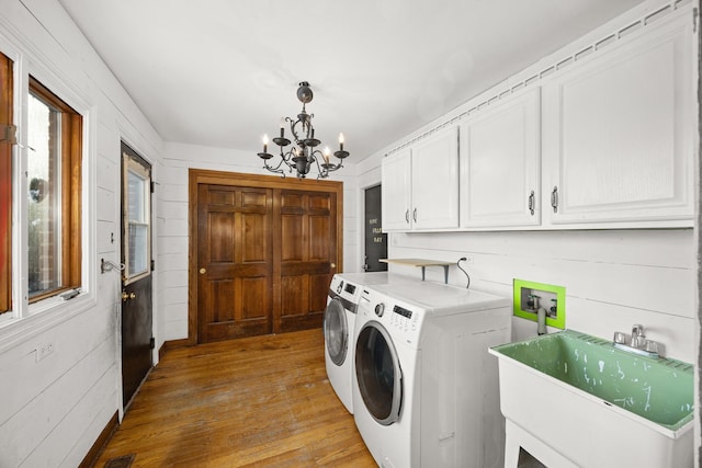 laundry room with sink, light hardwood / wood-style flooring, cabinets, washer and dryer, and a chandelier