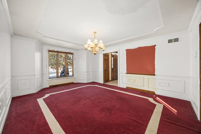 carpeted spare room with crown molding and a notable chandelier