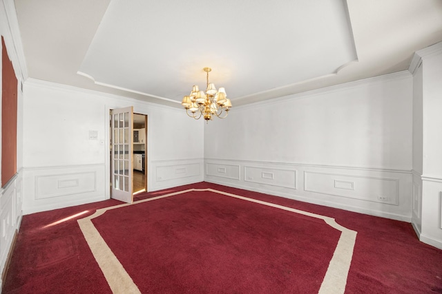 carpeted spare room with crown molding and a chandelier