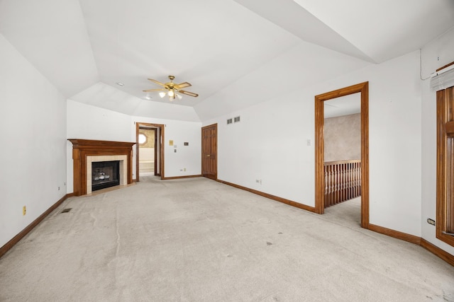 unfurnished living room with lofted ceiling, a fireplace, light colored carpet, and ceiling fan