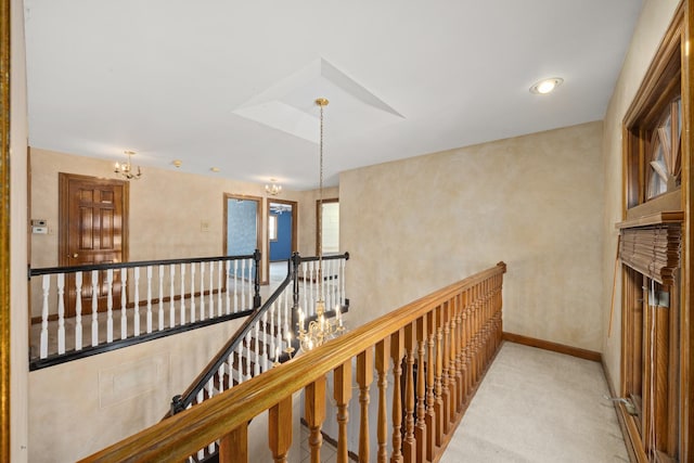 hall featuring an inviting chandelier and light carpet