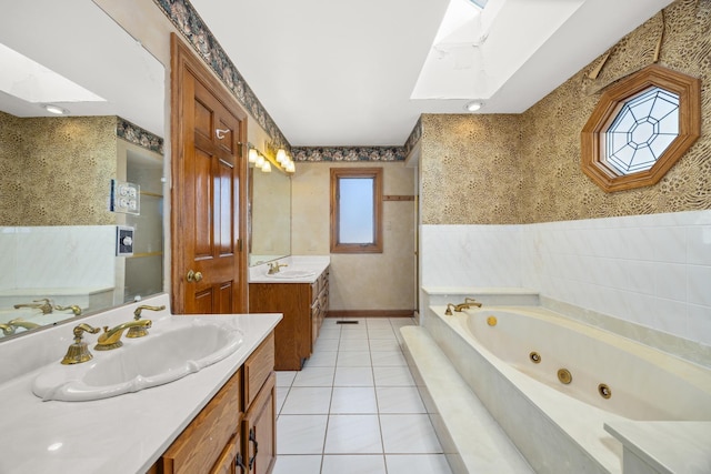 bathroom with a relaxing tiled tub, tile patterned floors, vanity, and a skylight