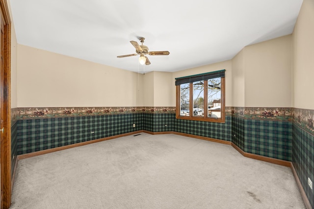 carpeted spare room featuring ceiling fan