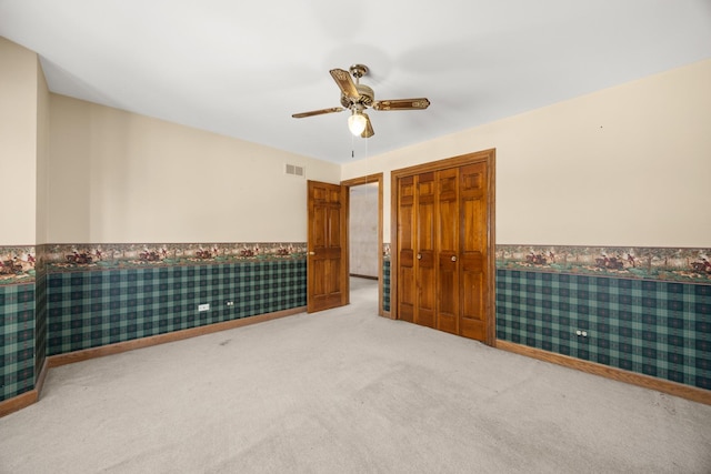 empty room featuring ceiling fan and carpet flooring